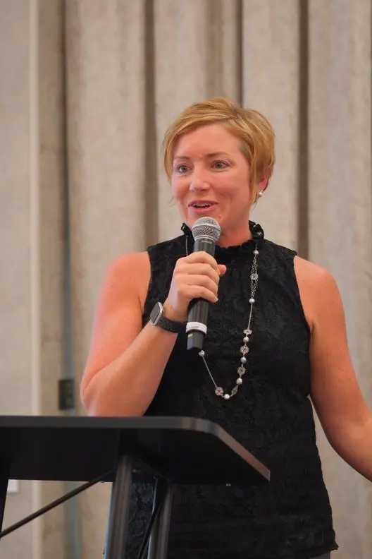 Stacy Olinger speaking at a lectern during a professional event